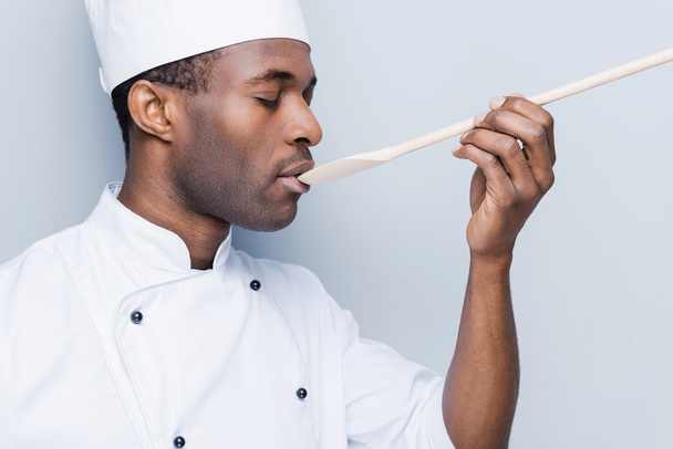 African chef trying eating from spoon - Φωτογραφία, εικόνα