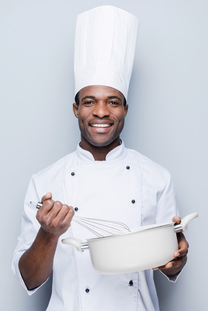 African chef mixing in casserole - Photo, Image