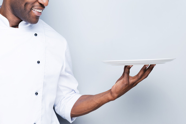 African chef holding empty plate - Foto, immagini