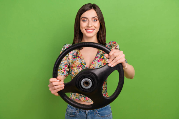 Photo of cheerful pretty girl toothy smile hands hold wheel isolated on green color background. - Foto, Bild