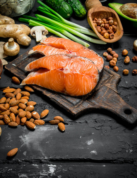 Healthy food. Raw salmon fish with organic food. On black rustic background. - Valokuva, kuva