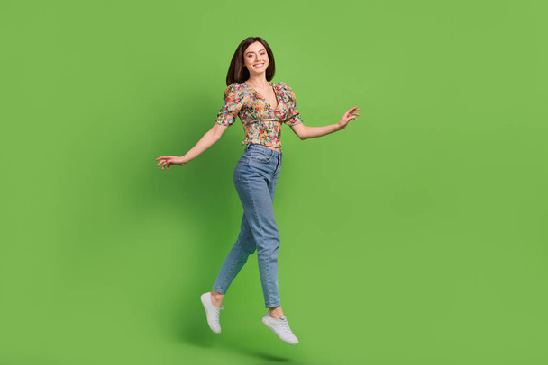 Портрет повного розміру весела збуджена дівчина, що стрибає, має гарний настрій ізольовано на фоні зеленого кольору
. - Фото, зображення