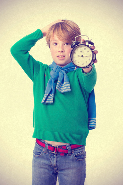 Worried child holding an alarm clock - Photo, Image