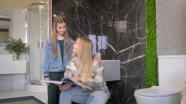 Egy európai család új kerámia csempét választ a saját fürdőszobájába. Koncepció lakás felújítás. Kiváló minőségű 4k felvételek - Felvétel, videó
