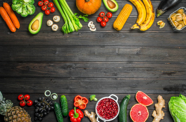 Healthy food. Assortment of organic fruits and vegetables. On a wooden background. - Fotoğraf, Görsel