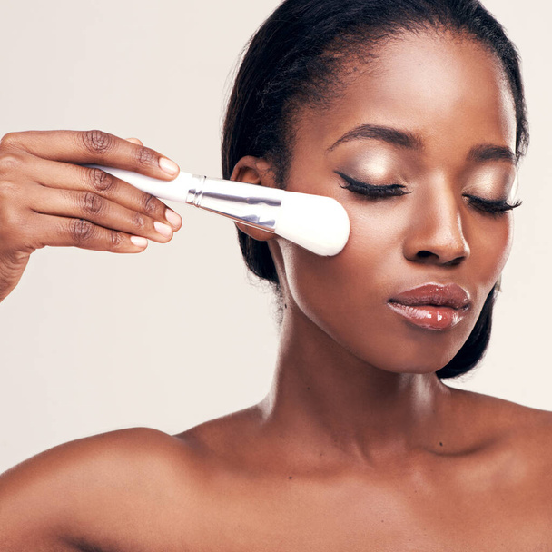 Skin care, makeup and black woman with brush on face in studio with cosmetic application tool. Skincare, blush and facial cosmetics, model with luxury contour beauty on white background with mockup - Photo, Image