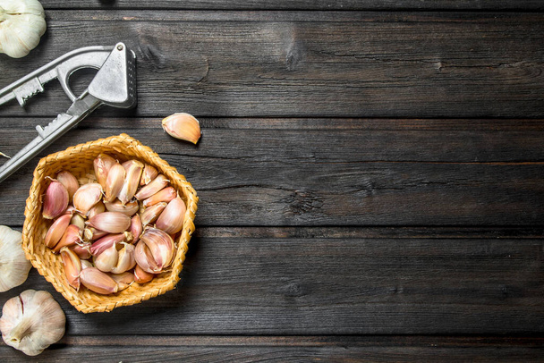 The slices of garlic in the basket. On wooden background - Foto, Imagem