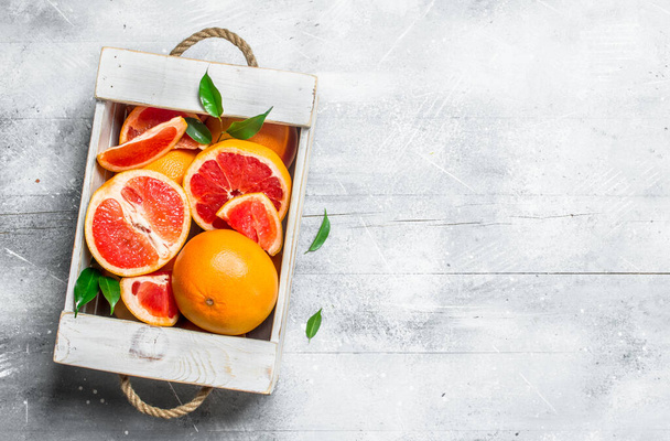 Pieces of ripe grapefruit on a tray. On white rustic background - Foto, imagen