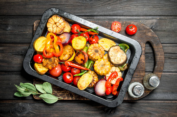 Different grilled vegetables with herbs and spices. On a wooden background. - Foto, Imagen