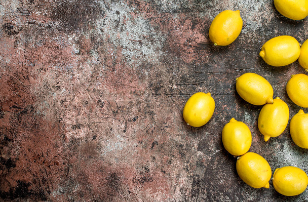 Fresh juicy lemons. On rustic background - Фото, изображение