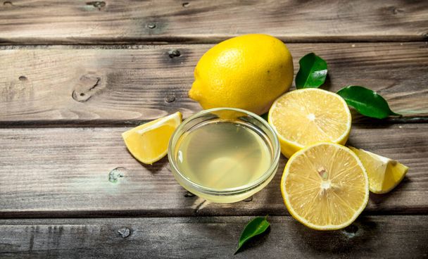 Lemon juice in the bowl. On wooden background - Fotoğraf, Görsel