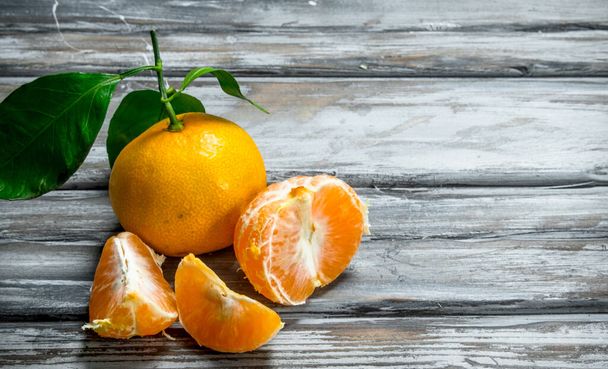 Fresh juicy mandarins with leaves. On wooden background - Foto, immagini