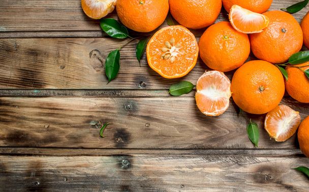Pieces of fresh mandarins. On wooden background - Zdjęcie, obraz