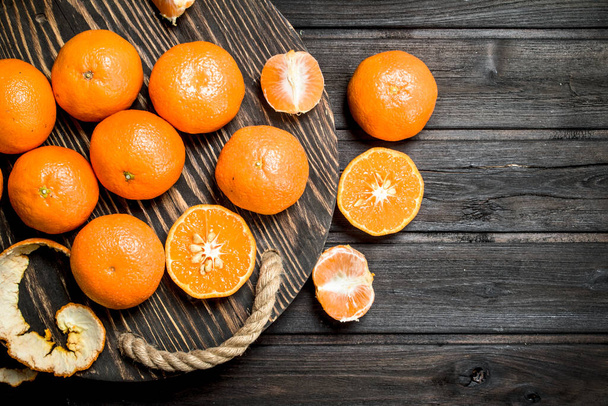 Juicy mandarins on a tray. On black wooden background - Foto, Imagem