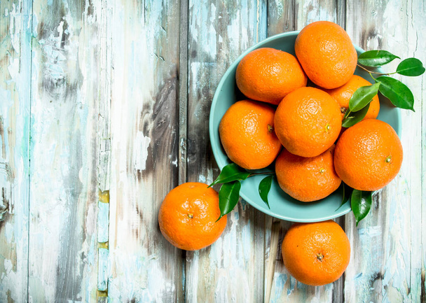 Ripe mandarins in the bowl. On wooden background - Foto, Imagem