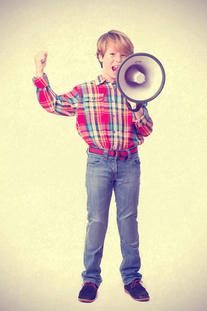 Angry kid shouting through a megaphone - Foto, afbeelding