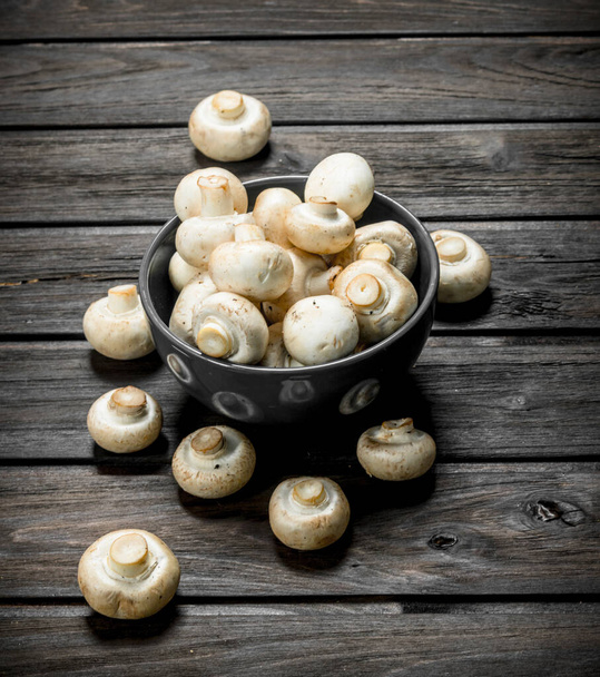 Fragrant fresh mushrooms in bowl. On black wooden background - Photo, Image