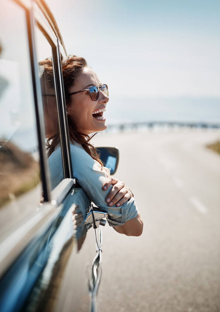 Szczęśliwy, wolność i podróż z kobietą w samochodzie, patrząc na widok z okna podczas gdy na otwartej drodze. Uśmiechnij się, podróżuj i baw się z młodą podróżującą kobietą w podróży podczas jej wakacji. - Zdjęcie, obraz