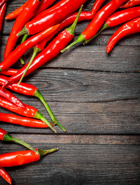 Hot red pepper. On black wooden background - Zdjęcie, obraz