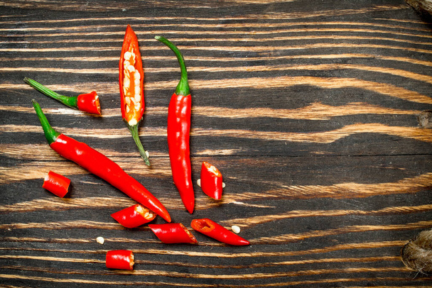 Sliced hot red pepper. On wooden background - Foto, Bild