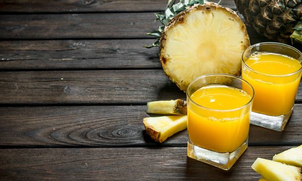 Pineapple juice in a glass. On wooden background - Photo, image