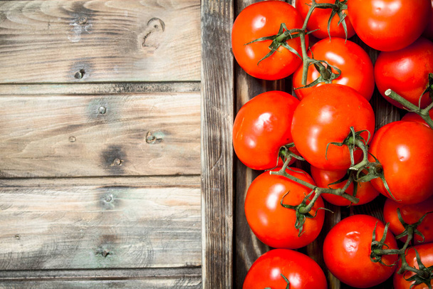 Fragrant red tomatoes on tray. On wooden background - Valokuva, kuva