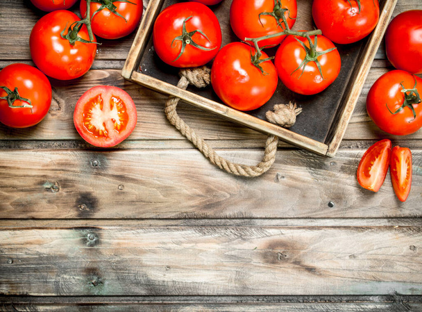 Ripe tomatoes on tray. On wooden background - Foto, immagini