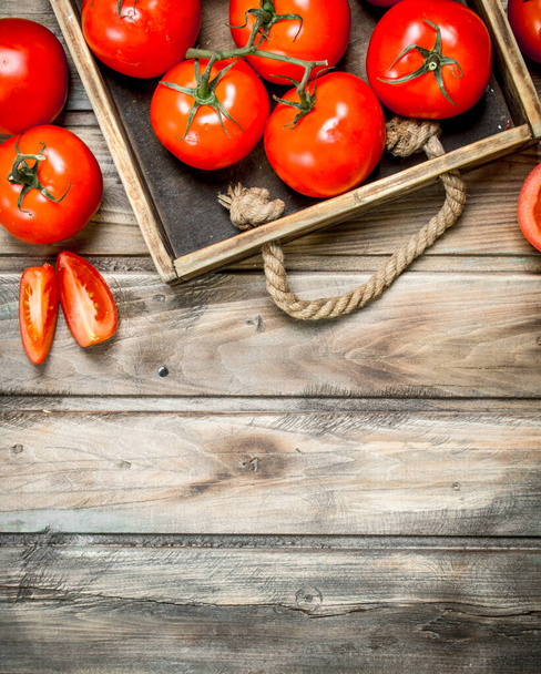 Ripe tomatoes on tray. On wooden background - Fotoğraf, Görsel