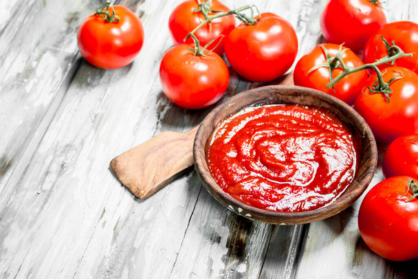 Tomato sauce in wooden bowl with scoop. On white wooden background - Φωτογραφία, εικόνα