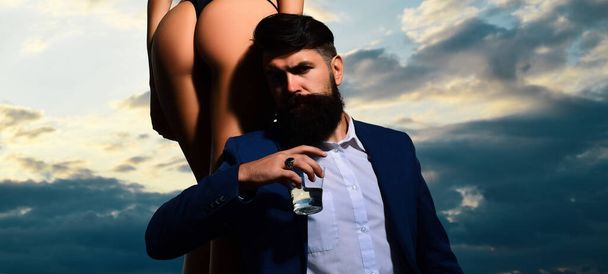 Rich man drink. Bearded businessman in elegant suit with glass of whiskey. Young couple in love outdoor - Foto, Imagem