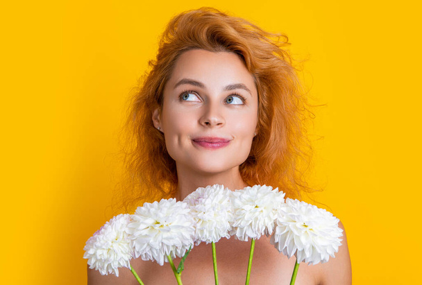 photo of cheerful woman beauty with chrysanthemum flowers. woman beauty with flowers isolated on yellow. woman beauty with flowers in studio. woman beauty with flowers on background. - Photo, Image