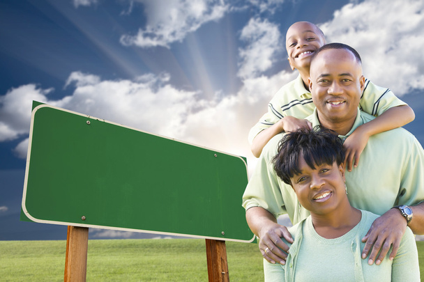 Afro-Amerikan ailesinin önünde boş yeşil yol levhası - Fotoğraf, Görsel