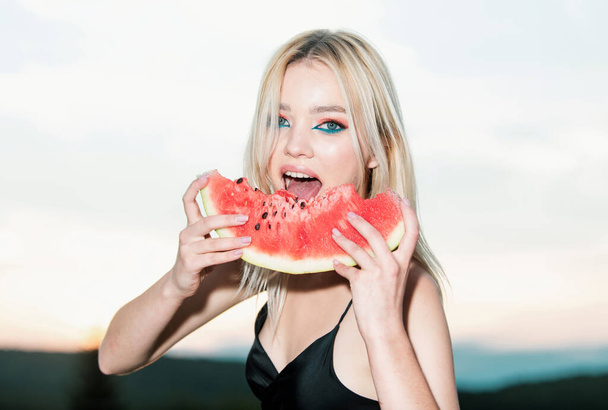 Sexy girl eating a watermelon. Fashion glamor portrait of beautiful sexy stylish blonde young woman model with bright makeup and red lips. Summer sexy watermelon - Foto, Bild