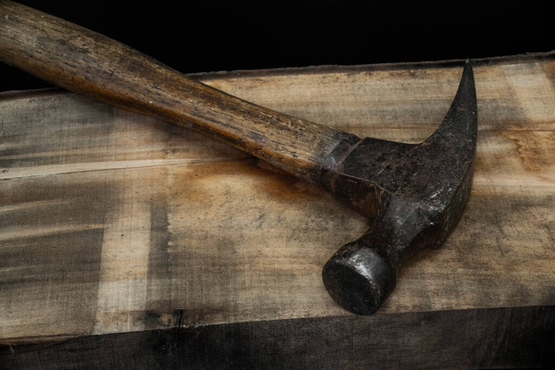close up of hammer on wood with black background with reduced vibrance, grungy, old, antique, vintage - Foto, imagen