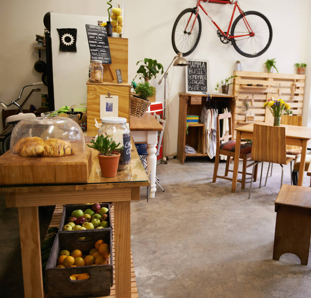 テーブル、椅子や家具や中小企業、ユニークなデザインとスタイルのビストロやカフェとインテリア、スペースと空のコーヒーショップ。背景、レストランのスタートアップや壁に自転車とフードカウンター. - 写真・画像