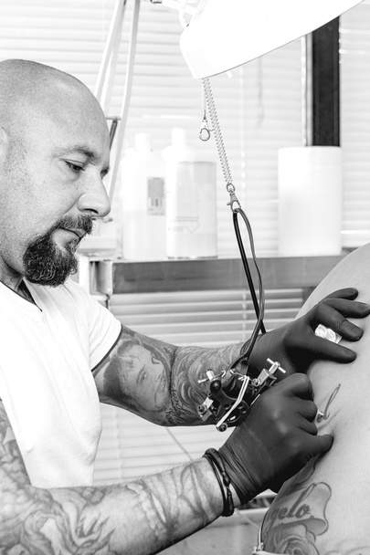 young tattooer tattooing a bac - Photo, Image