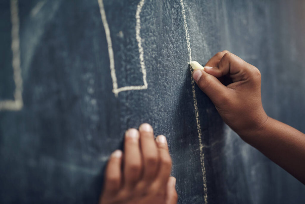 Drawing comes naturally to children. a young boy writing on a blackboard at home - 写真・画像