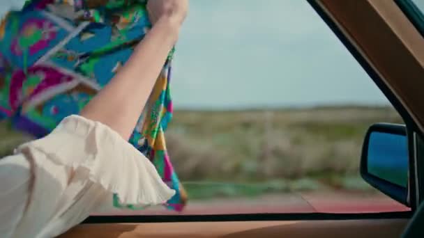 Mulher motorista segurando cachecol na janela do carro aberto condução estrada perto. Desconhecido jovem senhora desfrutar de passeio rápido balançando lenço no vento. Menina despreocupada turista sentindo-se livre relaxado em viagens de automóvel. - Filmagem, Vídeo