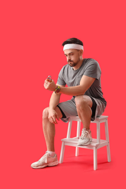 Sporty young man training on red background - Foto, immagini