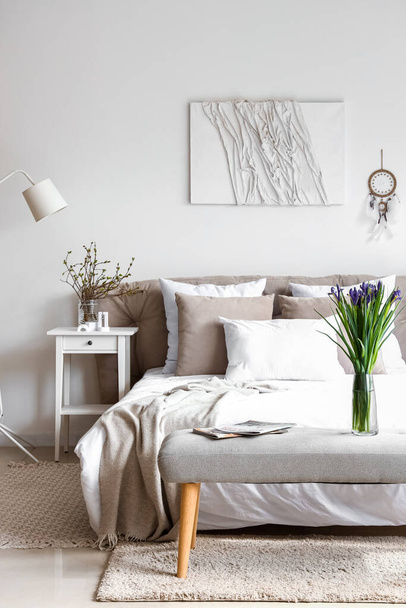 Sisustus valoisa makuuhuone kaunis iiris kukkia sängyn penkillä - Valokuva, kuva
