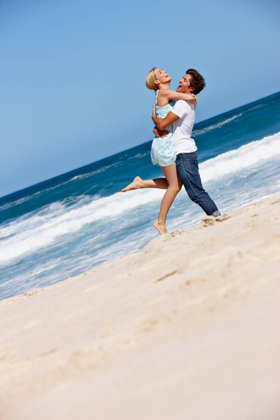 They live for the summer. a happy young couple enjoying a romantic day on the beach - Foto, imagen