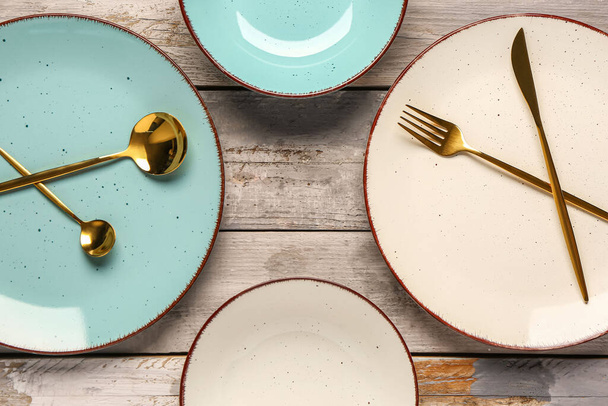 Состав с чистыми тарелками и столовыми приборами на деревянном столе - Фото, изображение