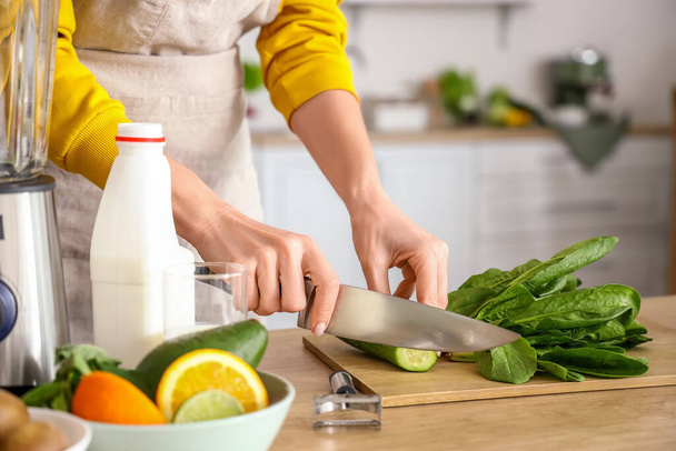 Dojrzałe kobieta cięcia ogórek dla zdrowego smoothie w kuchni, zbliżenie - Zdjęcie, obraz