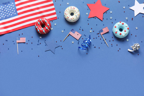 Komposition mit Donuts, USA-Flaggen und Konfetti auf blauem Hintergrund. Feier zum Unabhängigkeitstag - Foto, Bild