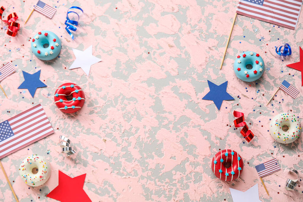 Композиция с пончиками, флагами США и конфетти на розовом гранж-столе. Праздник Дня независимости - Фото, изображение