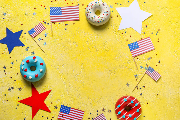 Telaio composto da ciambelle, bandiere USA e coriandoli sul tavolo giallo. Festa dell'indipendenza - Foto, immagini