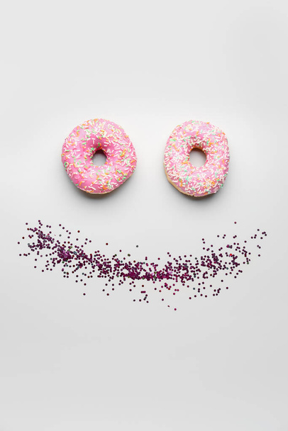 Lächeln aus Donuts mit Konfetti auf weißem Hintergrund - Foto, Bild