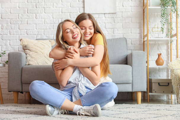 Young sisters hugging at home - Фото, изображение