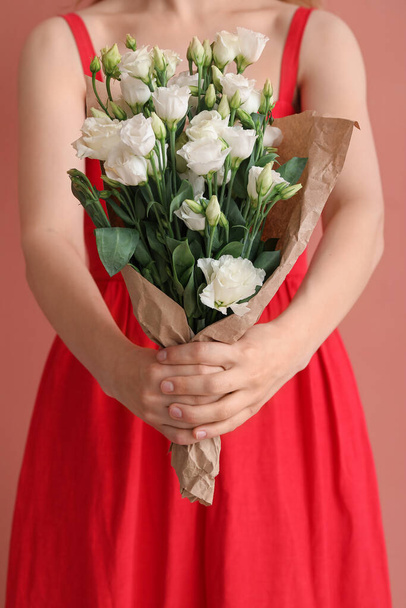 Young woman with bouquet of beautiful eustoma flowers on pink background - Foto, Bild