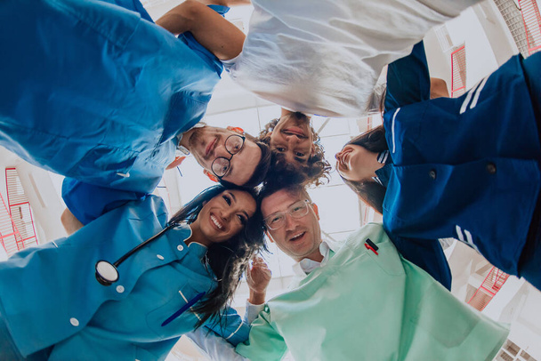  Een groep artsen, een verpleegkundige en een chirurg worden gevangen genomen in een oprechte omhelzing, die hun eenheid, teamwork en diepe verbondenheid in de gezondheidszorg tonen. - Foto, afbeelding